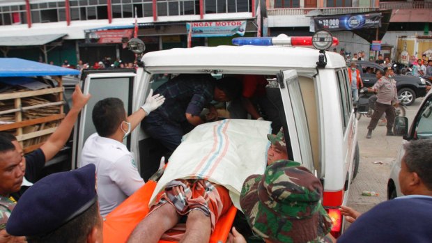 A victim of the earthquake is loaded into an ambulance in Pidie Jaya regency.