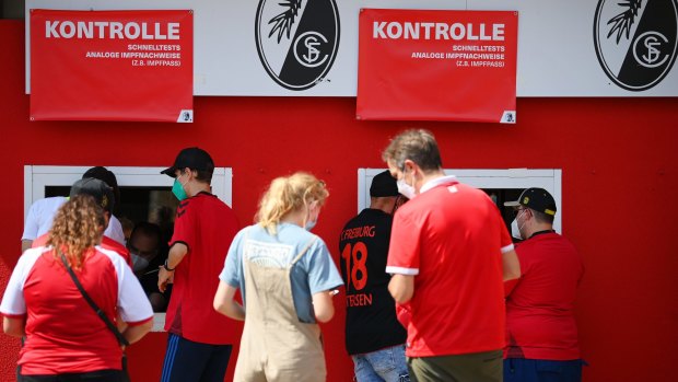 Fans queue to have their digital vaccination passes scanned prior to entering a soccer match in Freiburg im Breisgau, Germany. 