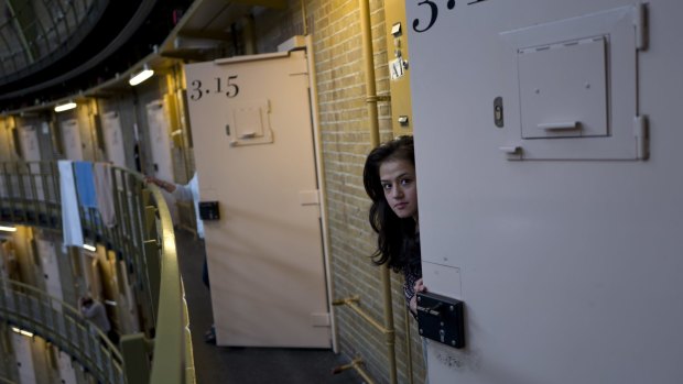 Afghan refugee Shazia Lutfi, 19, peeks through the heavy door of her room at De Koepel in Haarlem, Netherlands. 