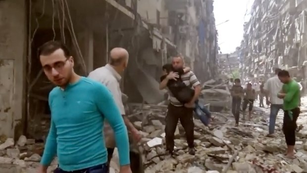 A man carries a child after airstrikes hit Aleppo last month. 