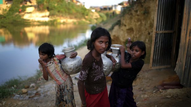 Rohingya Muslim girls carry water pots in Kutupalong refugee camp in Bangladesh. 