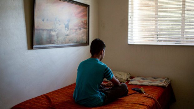 A 15-year-old boy from El Salvador in his uncle's home in Tucson, Arizona this month. He is asking for asylum after fleeing gang violence back home, but did not have a lawyer in immigration court. 