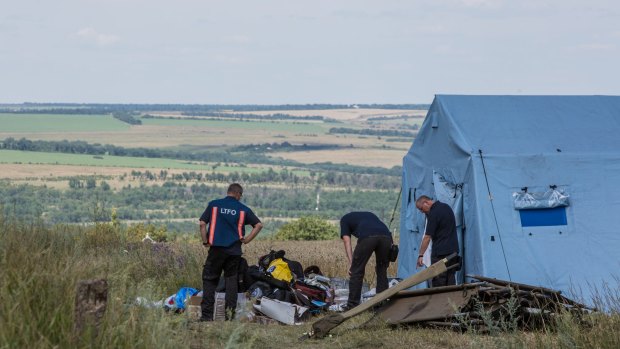 Inspectors from the Dutch government examine items at the Malaysia Airlines flight MH17 crash site.