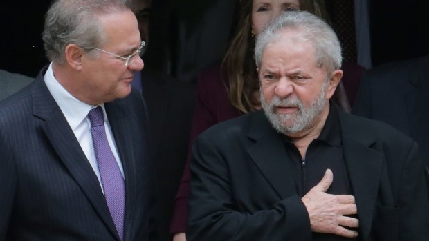 Former Brazilian president Luiz Inacio Lula da Silva, right, and Senate President Renan Calheiros chat at the end of a breakfast with senators of the government's allied base in Brasilia on Wednesday, before charges were laid.
