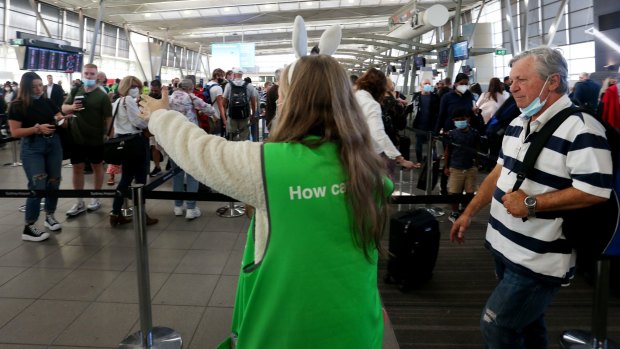 A staff member directs passengers at Sydney Airport ahead of the Easter holidays.