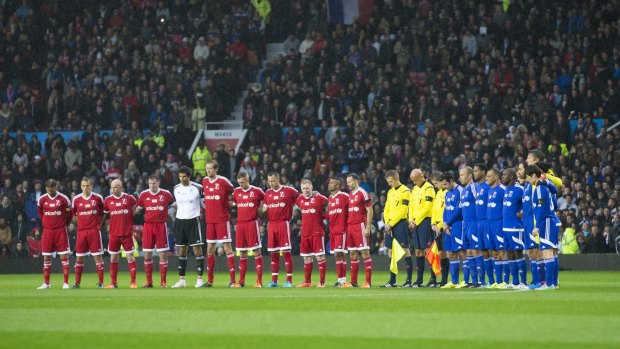 Respect: Players stand for a minute's silence for the victims of the Paris attacks before David Beckham's Match for Children at Old Trafford.