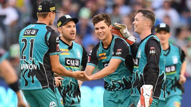 Mitchell Swepson (centre) celebrates with Heat teammates after taking a wicket against the Melbourne Stars.
