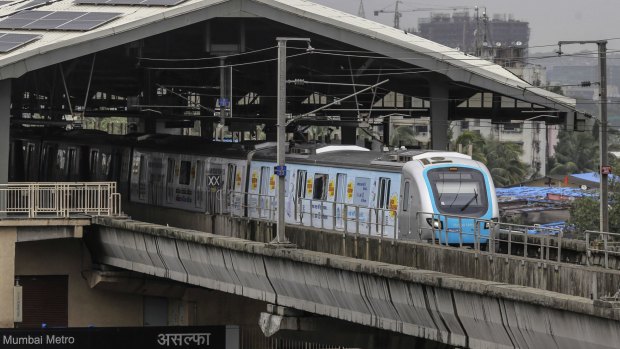 A train travels along a section of elevated track on the Mumbai metro.