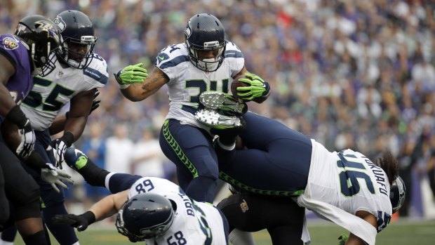 Happier times: Seattle running back Thomas Rawls takes on the Baltimore defence prior to braking his ankle.