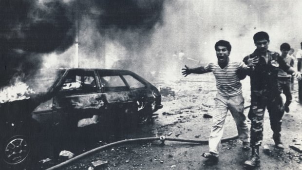 Bystanders are led away after a car bomb blast in Beirut in August 1985. 