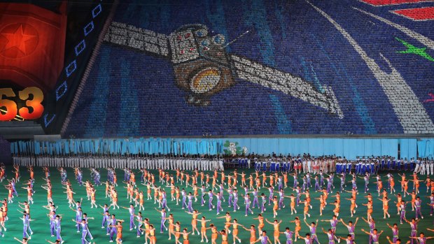North Koreans dance under a flashcard display of an image of a satellite during the Arirang Mass Games celebrations in Pyongyang last year.