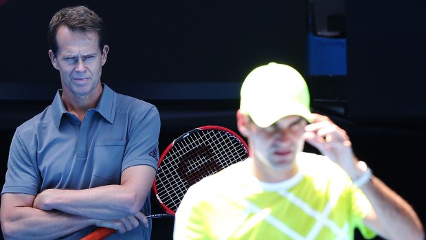 Coach Stefan Edberg watches on as Roger Federer practises.
