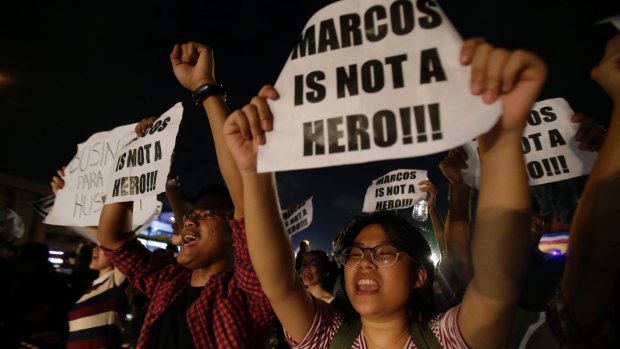 Protesters shout slogans as they gather along a busy road to oppose the burial of former Philippine dictator Ferdinand Marcos in Quezon, Philippines, on Friday.