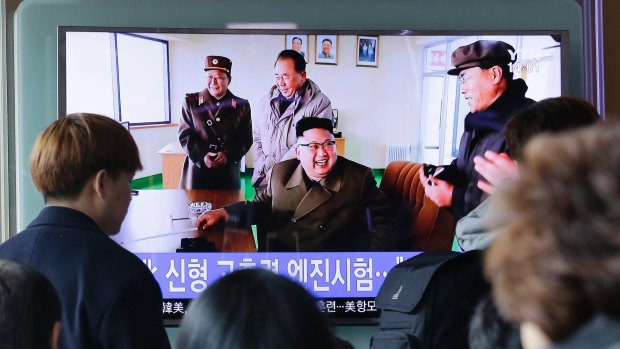People watch a TV news program showing an image of North Korean leader Kim Jong-un at the country's Sohae launch site, at Seoul Railway station.