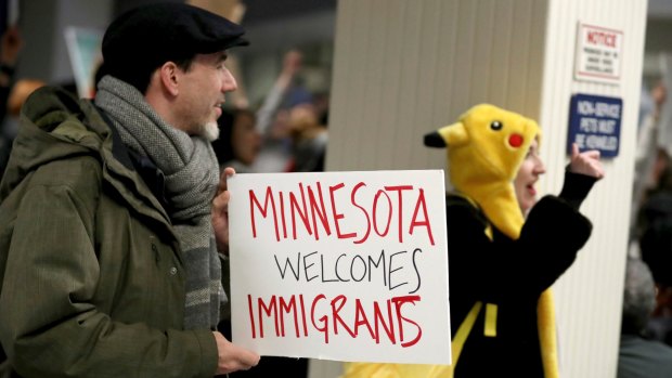 Adrian Hegeman holds a sign while joining other opponents to new immigration restrictions to protest an executive order signed by President Donald Trump.