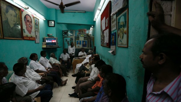 Supporters of India's Tamil Nadu state Chief Minister Jayaram Jayalalithaa watch TV news about their leader's health condition on Monday. 