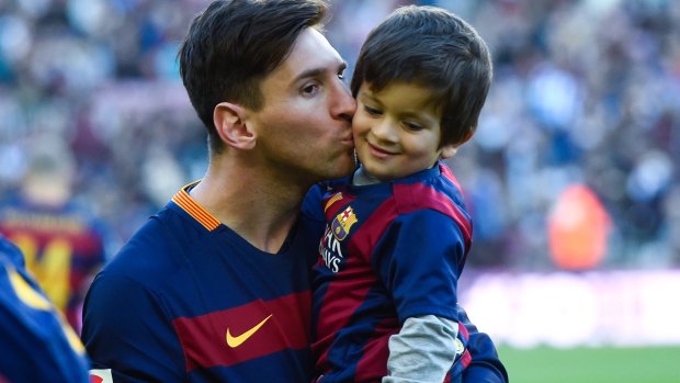 Lionel Messi kisses his son Thiago before the game.
