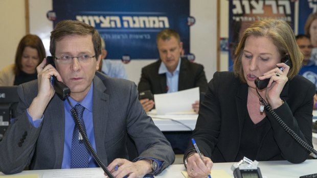 Zionist Union leaders Isaac Herzog, left, and Tzipi Livni work the phones at an election campaign centre in Tel Aviv.