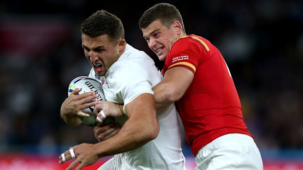 Sam Burgess is tackled by Scott Williams during the match between England and Wales.