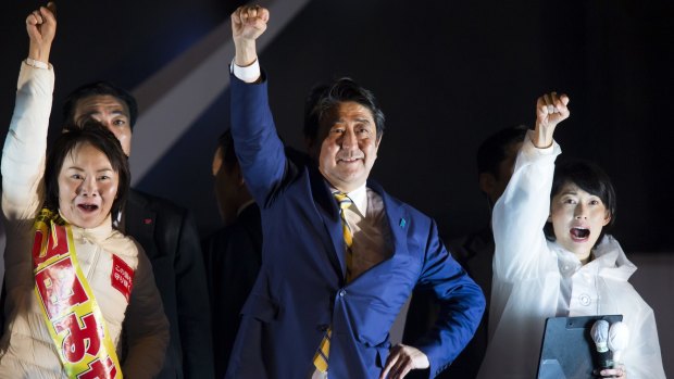 Exit polls say Shinzo Abe's (centre) Liberal Democratic party-led coalition was set to win 311 seats, keeping a majoirty in Japan's lower-house.