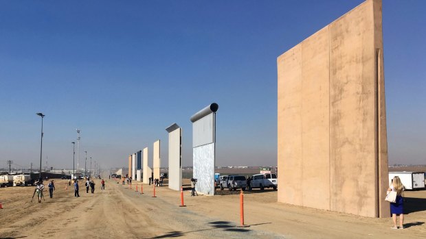 People look at prototypes for Trump's Mexico border wall in San Diego.
