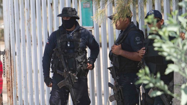 May 22, 2015: Mexican state police stand guard near the entrance of Rancho del Sol after the shootout with suspected gangsters. Mexico's National Human Rights Commission has concluded that 22 people were arbitrarily executed by federal police at the ranch. 