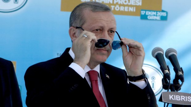 Turkish President Recep Tayyip Erdogan adjust his sunglasses before making a speech inaugurating an undersea pipeline to carry fresh water from Turkey to  northern Cyprus in the village of Mirtou.