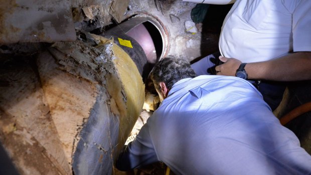 New York Governor Andrew Cuomo inspects the pipe the two inmates cut open as part of the escape.