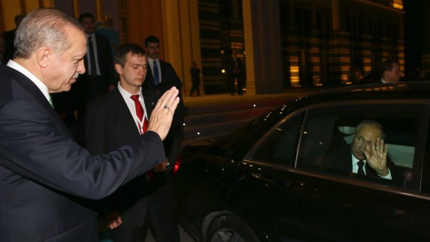 Turkish President Recep Tayyip Erdogan, left, waves goodbye to Russian President Vladimir Putin following their meeting in Ankara.