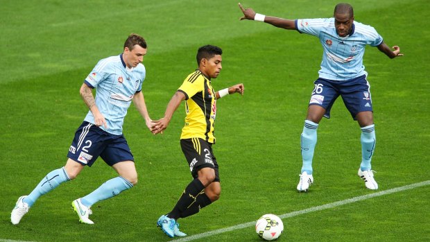 Chase to the top: Roy Krishna of the Phoenix evades Sebastian Ryall, left, and Jacques Faty of Sydney FC during the A-League match on Saturday.