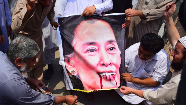 Pakistani protesters burn a caricature of Aung San Suu Kyi in a protest against ongoing violence against the Rohingya Muslim minority in Myanmar.