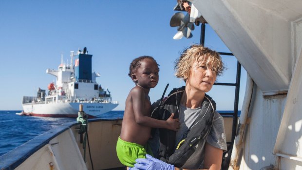 A Spanish nurse of Proactiva Open Arms NGO carries a child rescued from the Mediterranean Sea aboard the Golfo Azzurro ship, operated by Proactiva.