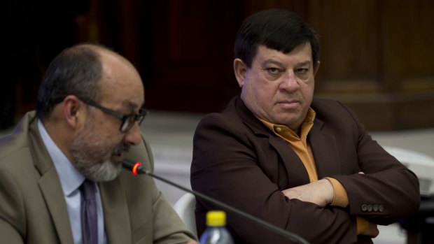 Former army officer Esteelmer Francisco Reyes Giron, right, listens to his lawyer Moises Galindo during the trial against him.