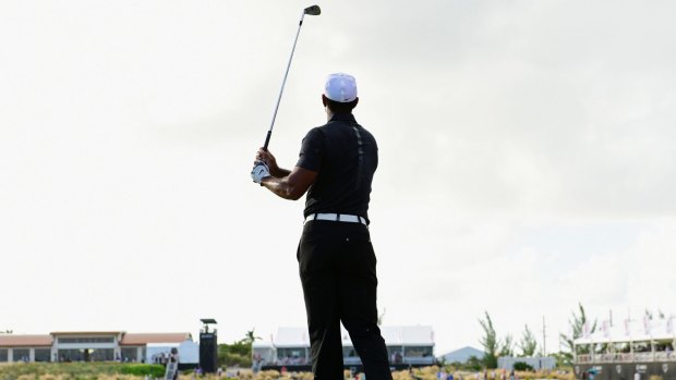 Tiger Woods watches his ball from the fairway.
