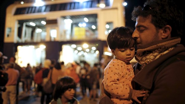 A Syrian refugee and his daughter arrive in the port of Piraeus, near Athens, after leaving Kos.