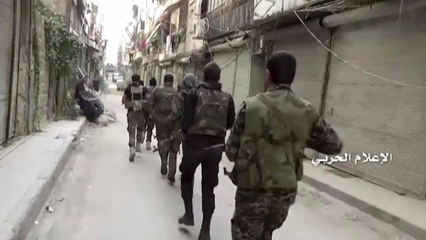 Government troops patrol inside the Bustan Al-Basha neighbourhood of Aleppo, Syria on Tuesday.