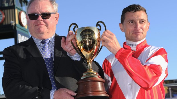 Opie Bosson poses with trophy and trainer Murray Baker after Mongolian Khan won Race 9.