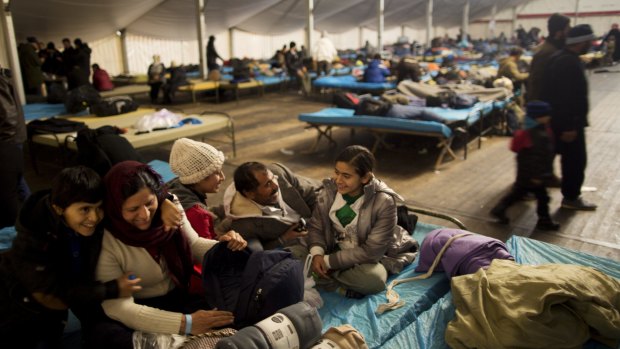 The Qasu family, a Yazidi refugee family from Sinjar, Iraqi, laugh with each other while resting on a bed in a shelter in Salzburg, Austria, this month.