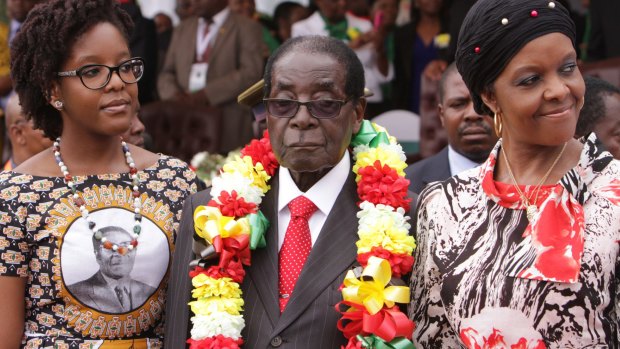 Zimbabwe's President Robert Mugabe is flanked by his daughter Bona and wife Grace during celebrations to mark his 91st birthday in the resort town of Victoria Falls on Saturday.
