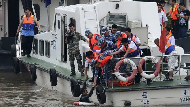 Diver Guan Dong is pulled up to a boat after rescuing 21-year-old crew member Chen Shuhan.