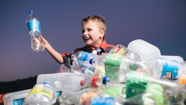 Lake Ginninderra scout Oliver Georgiou, 6, with a pile of bottles and cans. Groups like the scouts would benefit from the introduction of an ACT container deposit scheme.