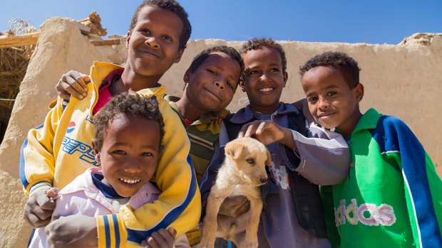 Local boys holding puppy in Nubian village on the Nile.