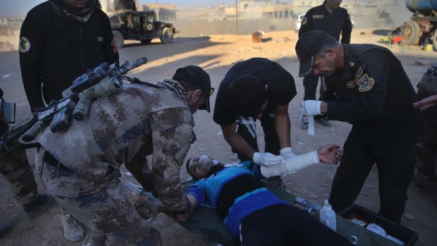 Iraqi special forces soldiers   treat a civilian man injured by a mortar shell at a field hospital in Mosul's al-Samah district.