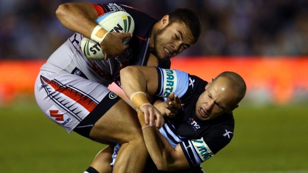Coming to grips: Warriors rookie Tuimoala Lolohea is tackled by Sharks veteran Jeff Robson.