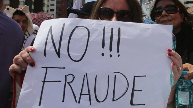 A supporter of Guillermo Lasso holds a sign reading "No to Fraud!" during Monday's protest in Quito.