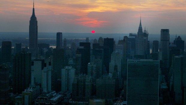 The sun sets over a darkened Manhatten skyline in Vincent Laforet's image of New York during a 2004 blackout.