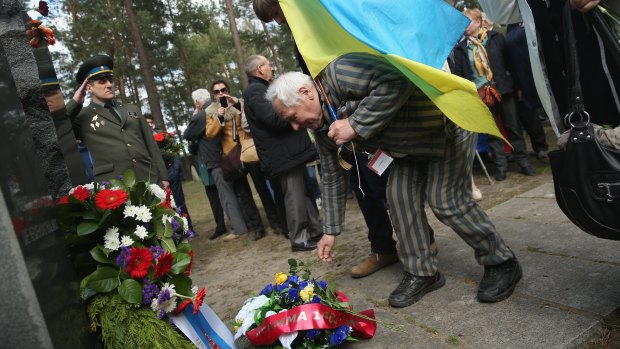 Petr Mischtschuk, from Ukraine, was imprisoned as a 14-year-old by the Nazis at the Buchenwald and Sachsenhausen concentration camps. He lays a flower during ceremonies marking the 70th anniversary of the liberation of Sachsenhausen.