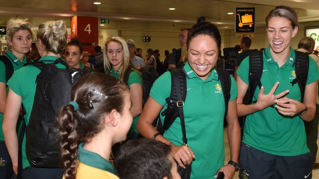 Welcome home: Kyah Simon and Alanna Kennedy (right) arrive at Sydney Airport.