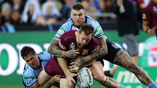 Solid defence: Michael Morgan of the Maroons drops the ball in a tackle by Mitchell Pearce and Josh Dugan.