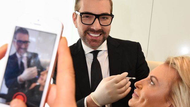 Snapchatting cosmetic surgeon Dr Kourosh Tavakoli with a staff member. 